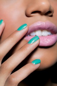 young woman with teal colored nails and pink lips